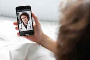 Free photo sick man having a video call with a doctor