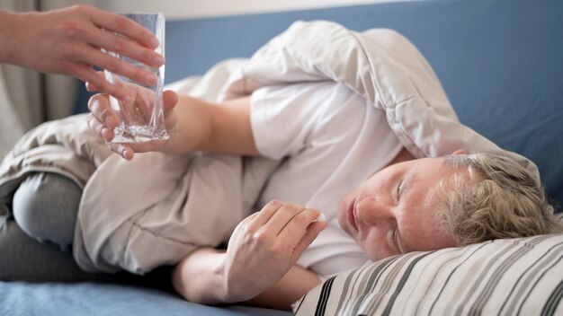 Sick person receiving a glass of water