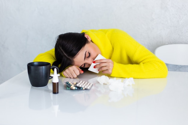 Free Photo sick woman with pills at kitchen table