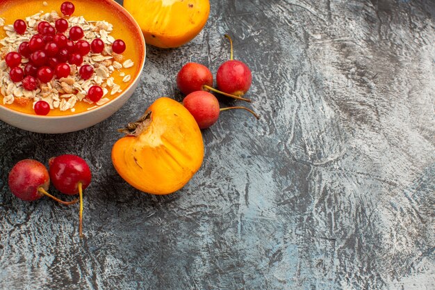 Side close-up view berries cherry bowl of red currants the appetizing persimmons