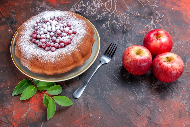 Free photo side close-up view a cake an appetizing cake with red currants apples leaves fork