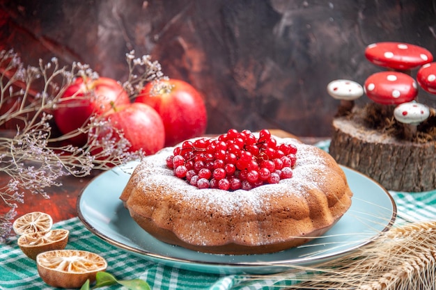 Side close-up view a cake an appetizing cake with red currants on the white-blue tablecloth apples