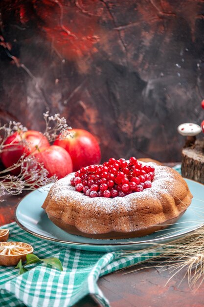 Side close-up view a cake a cake with red currants on the tablecloth three apples wheat ears