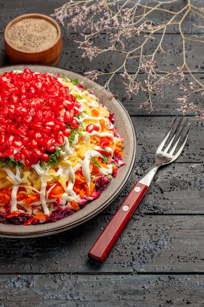 Free Photo side close-up view christmas food bowl of spices and fork next to the plate of appetizing christmas dish and tree branches