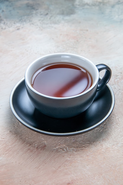 Side close-up view a cup of tea a cup of tea on the black saucer