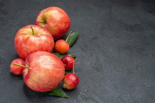 Side close-up view fruits the appetizing berries and apples with leaves