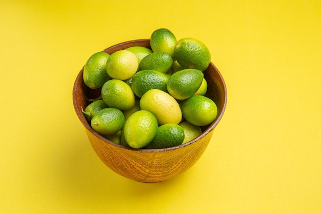 Side close-up view fruits the appetizing green fruits on the yellow surface