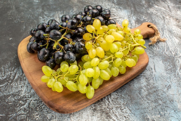 Side close-up view grapes the appetizing grapes on the wooden board on the table