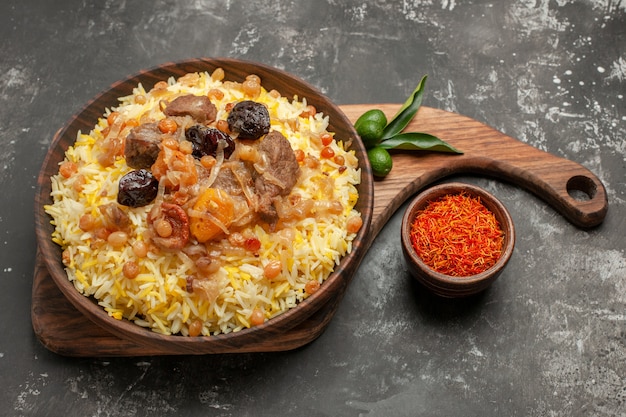 Free Photo side close-up view pilaf bowl of spices pilaf citrus fruits on the board