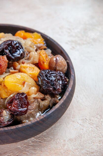 Side close-up view pilaf pilaf of rice dried fruits chestnuts on the table