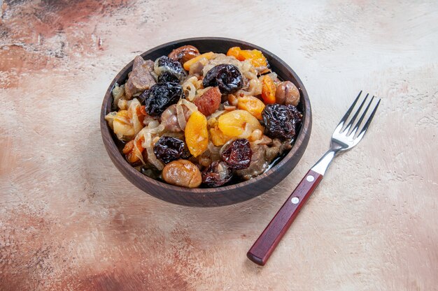 Side close-up view pilaf rice with dried fruits in the bowl fork