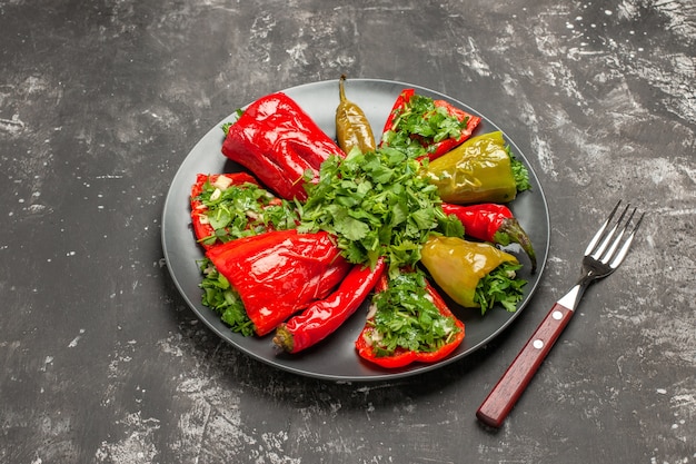 Free photo side close-up view plate of peppers the appetizing colorful peppers with herbs fork