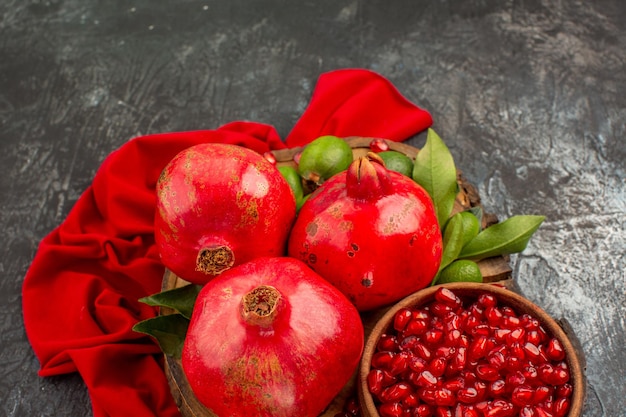 Free photo side close-up view pomegranates seeds of pomegranate pomegranate with leaves on the kitchen board