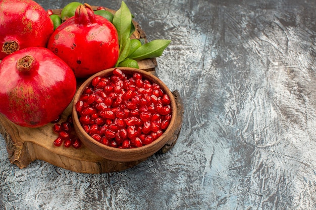 Side close-up view pomegranates tasty pomegranate with green leaves on the cutting board