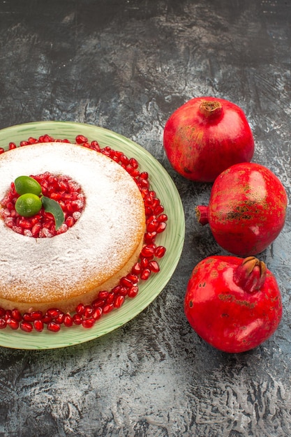 Free photo side close-up view seeds of pomegranates three red pomegranates and the appetizing cake