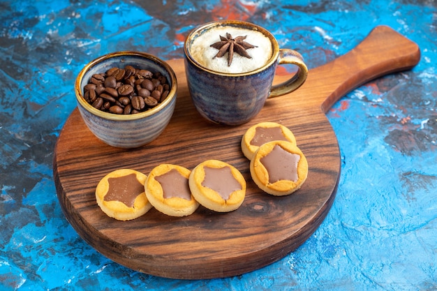 Free Photo side close-up view sweets a cup of coffee cookies and coffee beans on the board