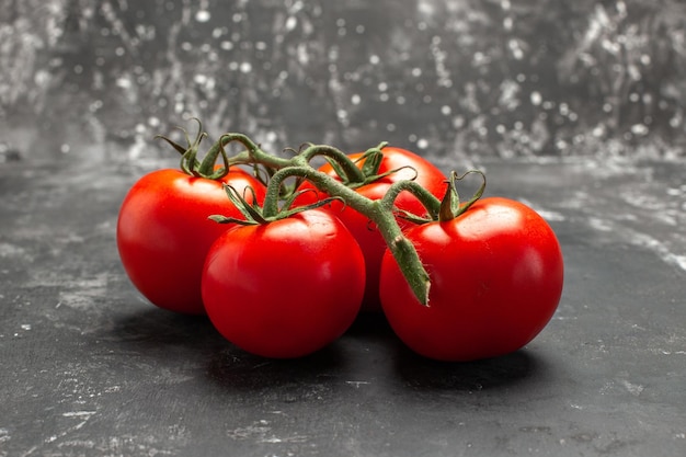 Side close-up view tomatoes appetizing tomatoes with stalks on the black background