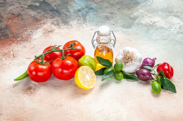 Side close-up view vegetables tomatoes oil bell pepper onion garlic hot pepper lemon