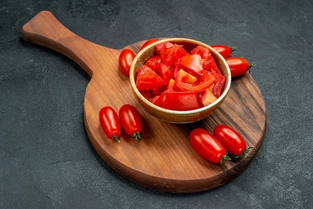 Side close view of tomatoes on plate stand on dark grey background