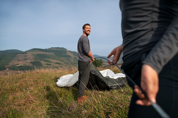 Free photo side view adventurous couple bivouacking