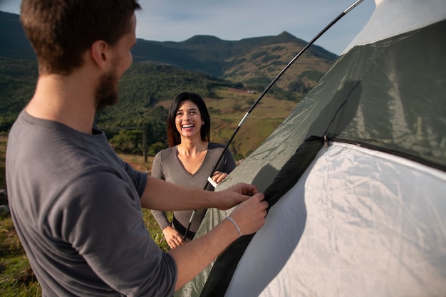 Free photo side view adventurous couple bivouacking