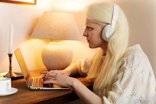 Side view albino woman working on laptop