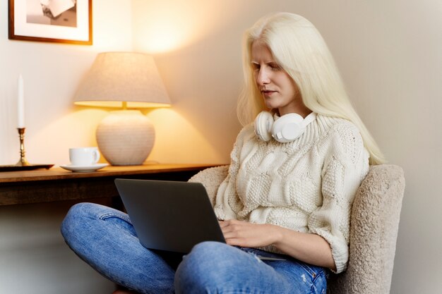 Side view albino woman working on laptop