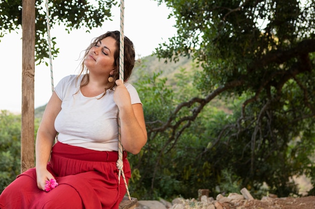 Side view of alluring woman outdoors in swing