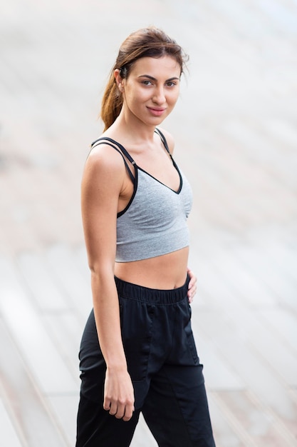 Free photo side view of alluring woman posing outdoors while exercising