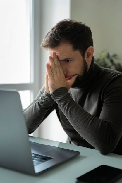 Side view anxious man working at home