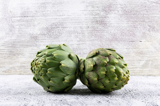 Side view artichokes on light gray background. horizontal space for text