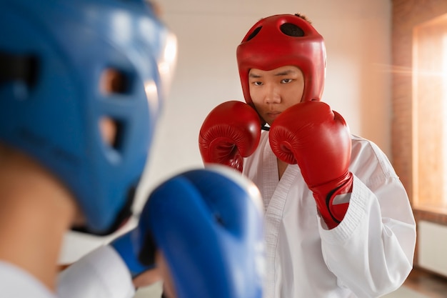 Free Photo side view asian people practicing taekwondo