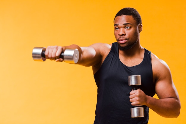 Side view of athletic man exercising with weights