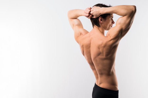 Side view of athletic man showing off muscle body