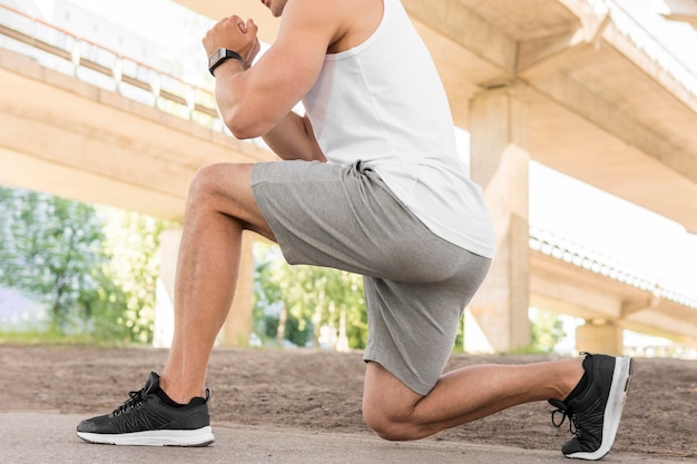 Side view athletic man stretching outside