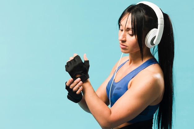 Side view of athletic woman in gym wear with headphones