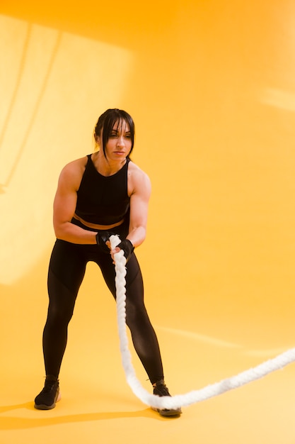 Side view of athletic woman holding rope