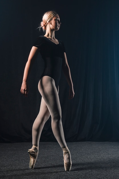 Side view of ballerina in leotard and pointe shoes