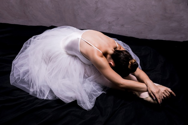 Free photo side view ballerina stretching