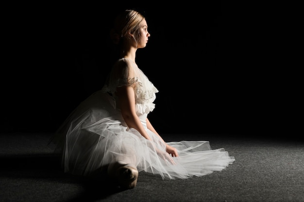 Free Photo side view of ballerina in tutu dress doing a split