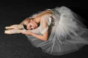 Free photo side view of ballerina in tutu dress stretching