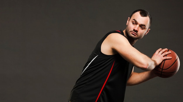 Free photo side view of basketball player posing while playing