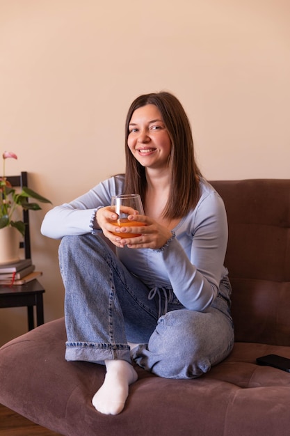 The side view of beautiful woman looking at camera and relaxing at home