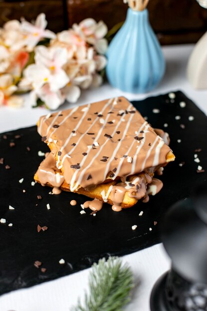 Side view of belgian waffle with milk chocolate on top on the table