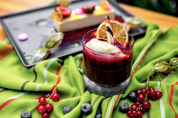 Side view berry souffle dessert with a slice of dried orange and berries