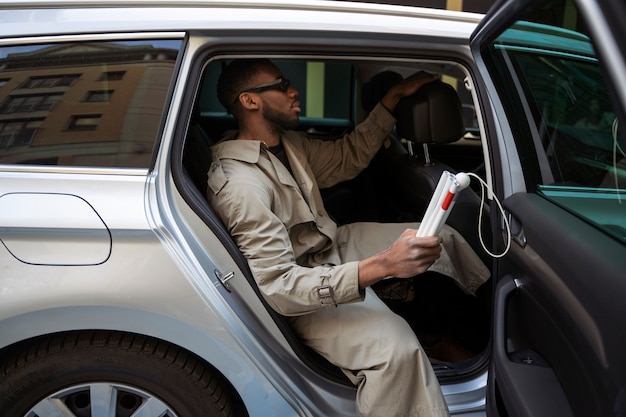 Side view blind man getting out of car