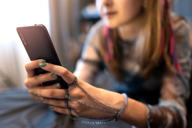 Free Photo side view blurry girl holding smartphone