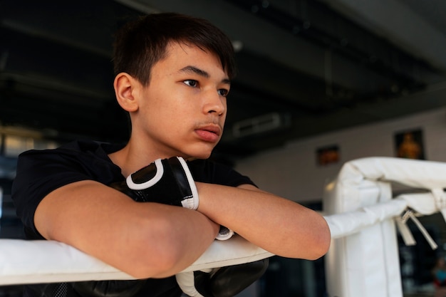 Free photo side view boy learning boxing