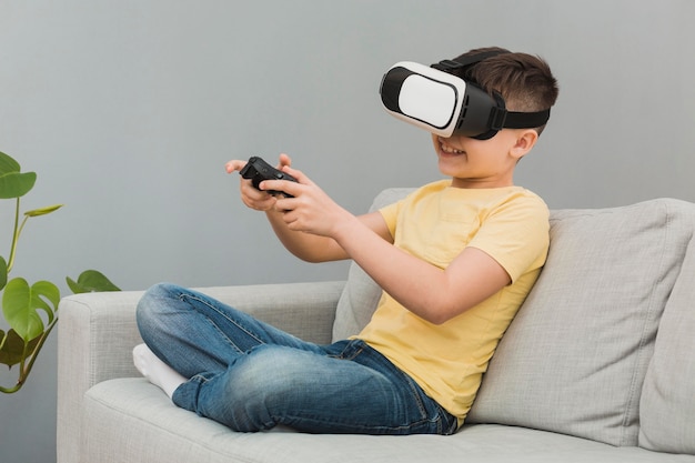 Side view of boy playing video games with virtual reality headset