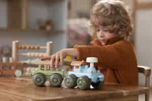 Free photo side view boy playing with ecological toys